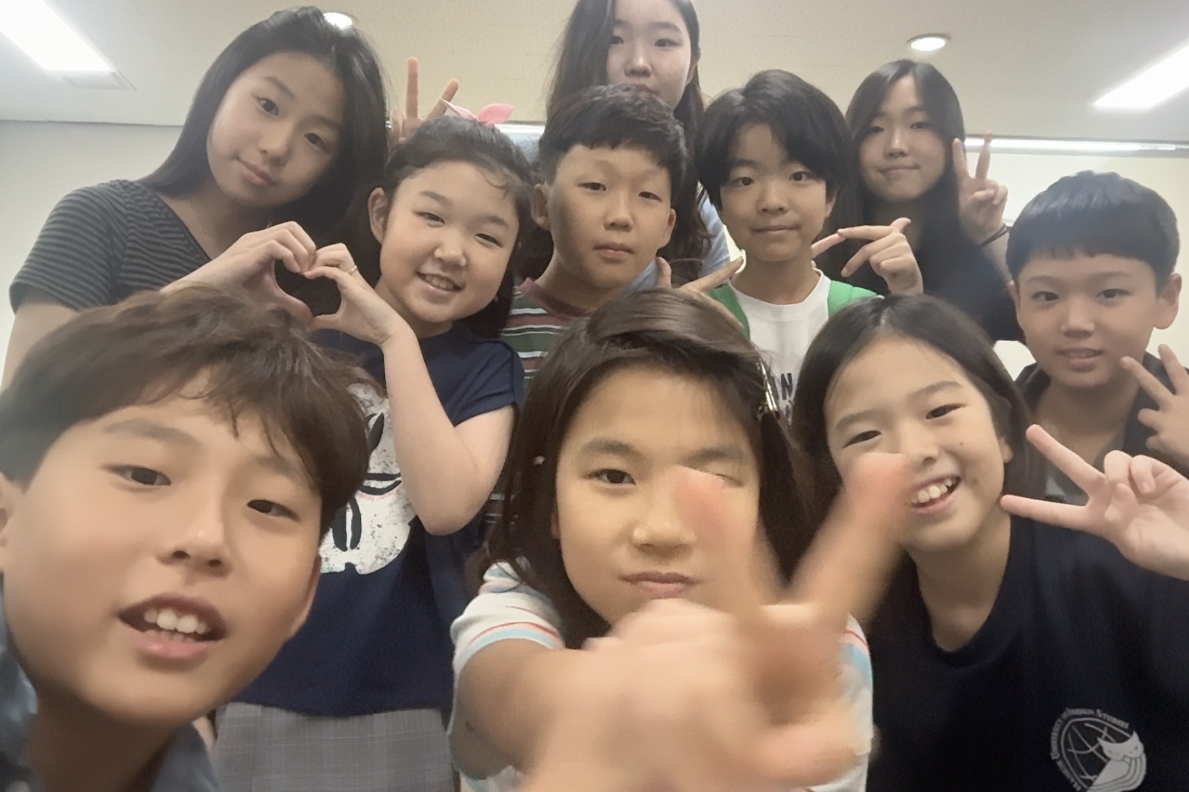Group photo with students making heart and peace sign hand gestures