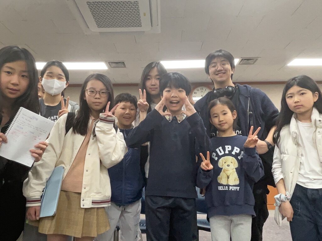 Group photo with students holding up notes and worksheets
